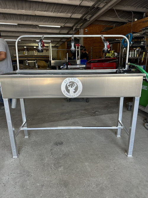 Aluminum cleaning station with raised trough and spray nozzles.