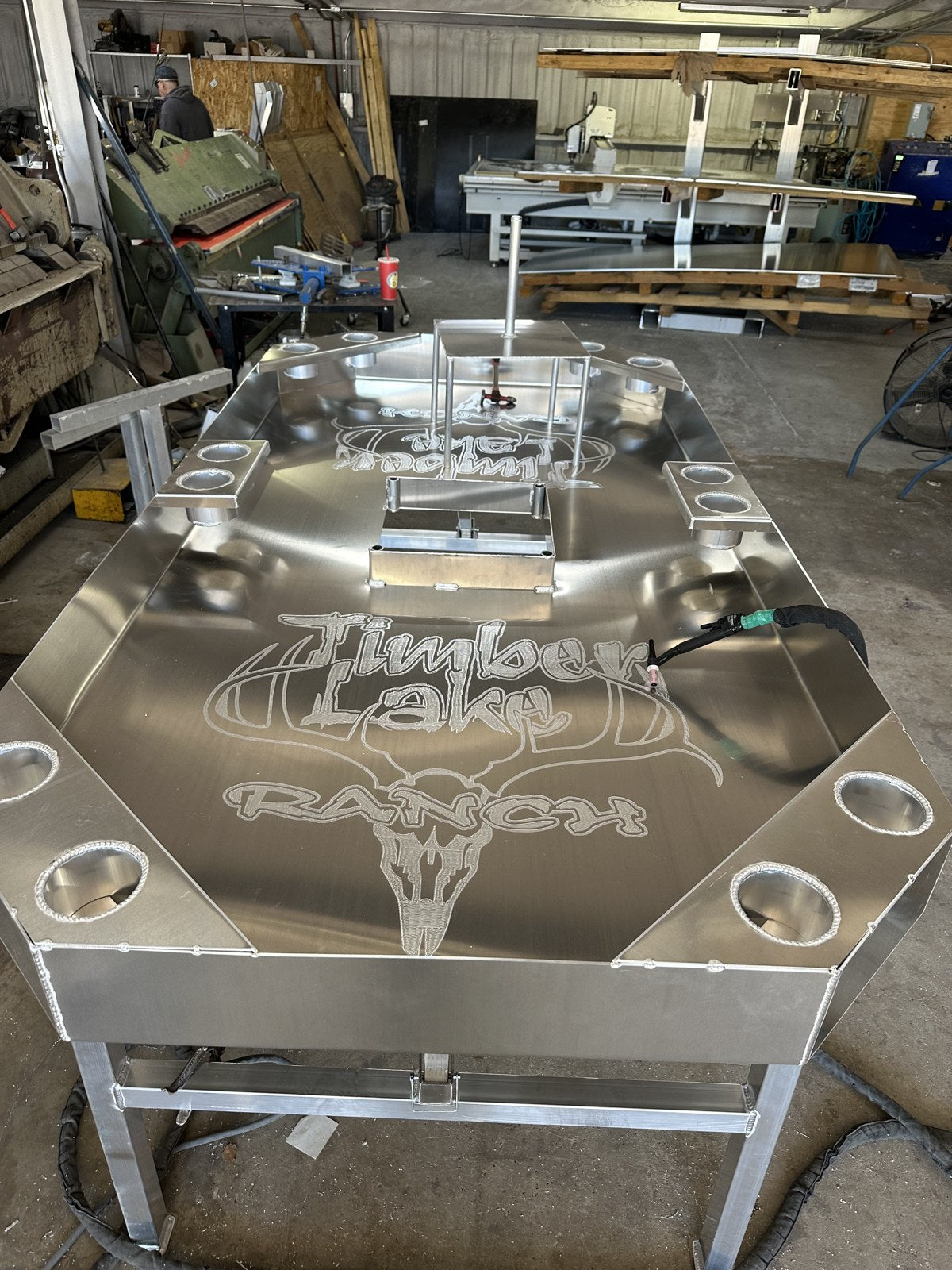 Octagonal aluminum crawfish table with twelve cup holders.