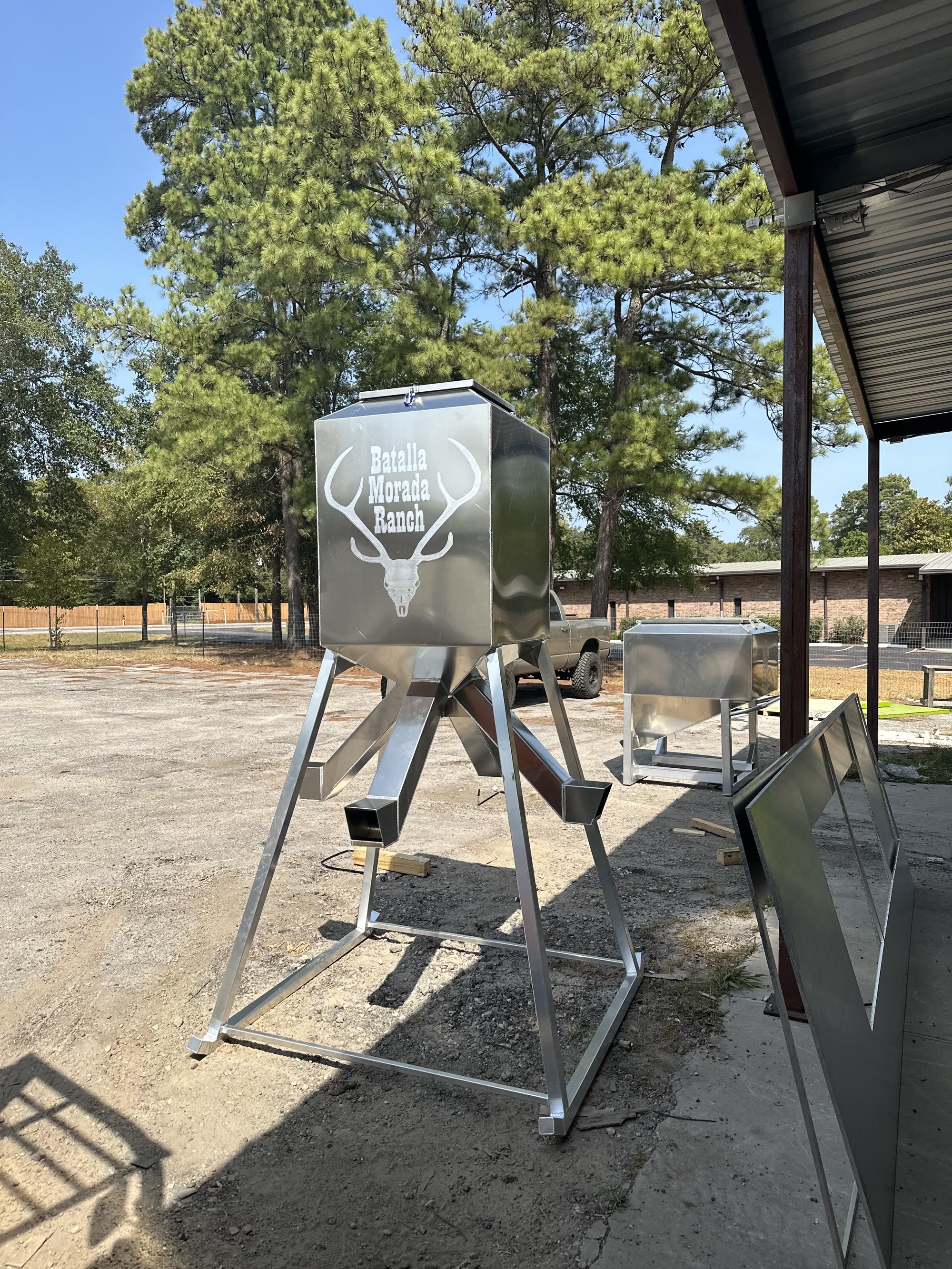 Aluminum protein feeder on braced legs with four spouts.